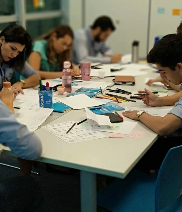 Equipe reunida em mesa de trabalho desenvolvendo projetos de inovação em saúde no SESI.