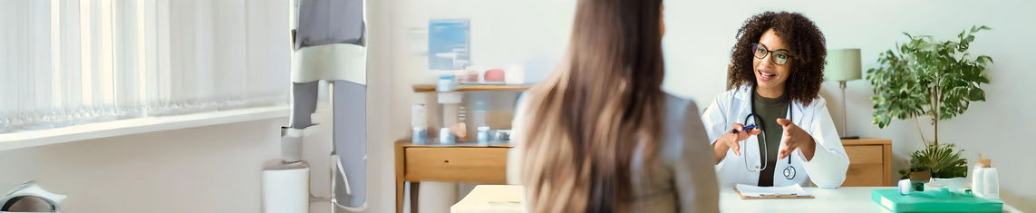 Médica conversando com paciente em consultório.